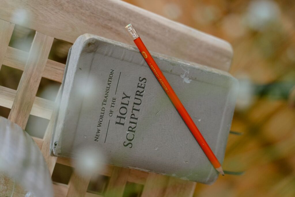 A close-up of the Holy Scriptures with a pencil on top, symbolizing study and reflection.