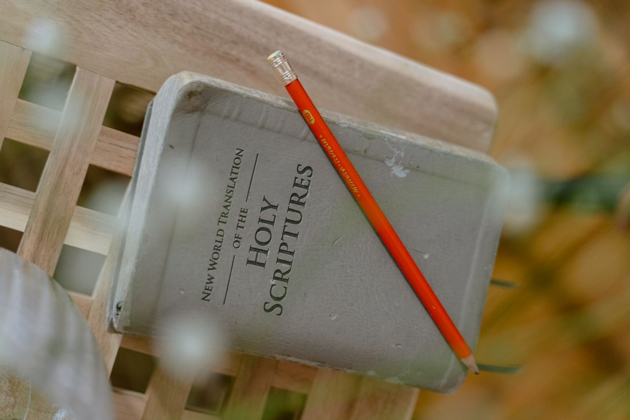 A close-up of the Holy Scriptures with a pencil on top, symbolizing study and reflection.
